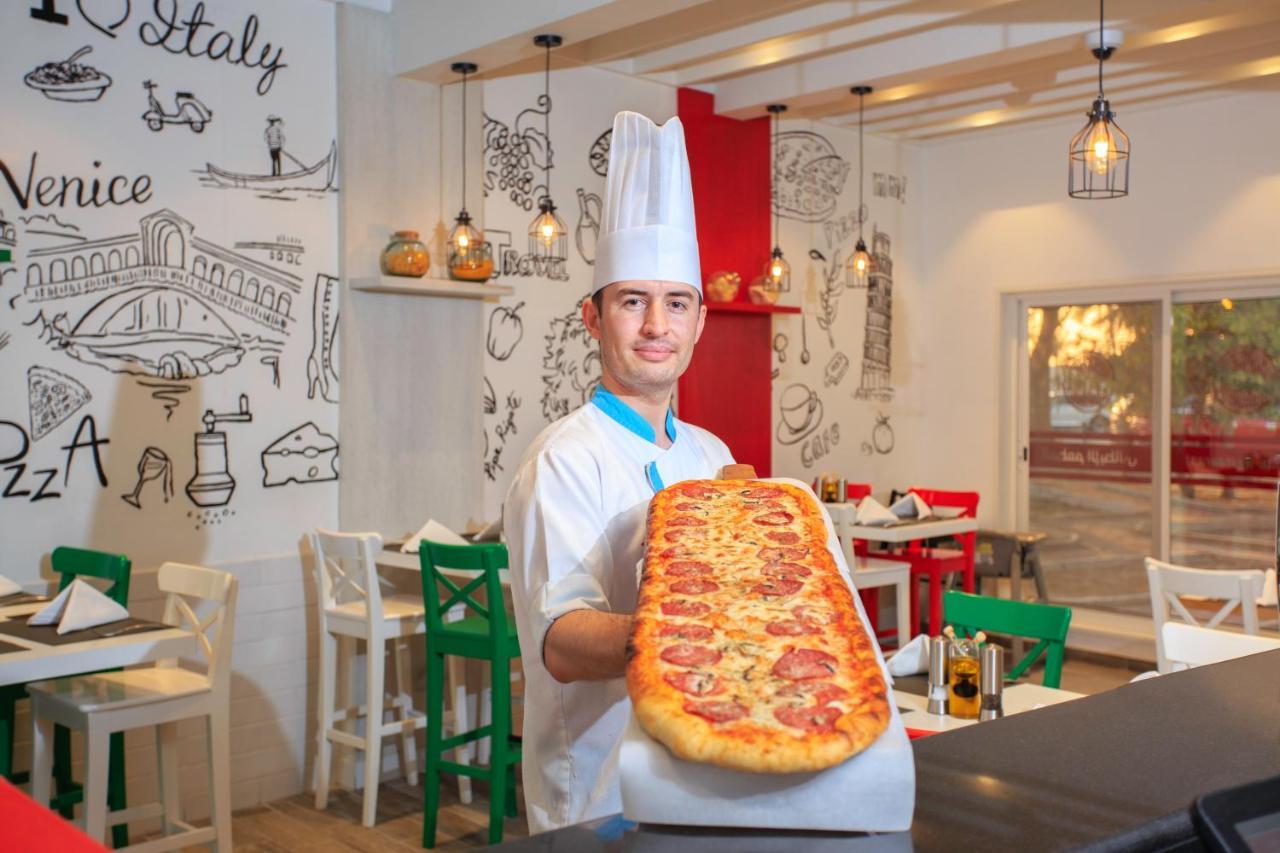 Sealine Beach, a Murwab Resort Mesaieed Exterior foto A pizzaiolo with a metre-long pizza